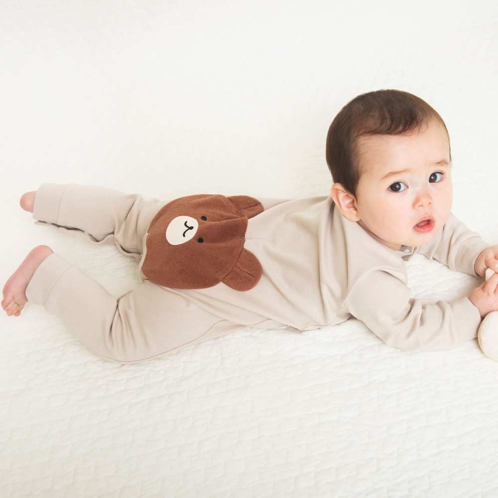 仰向けになって、足に手を伸ばす小さな赤ちゃん。Premium写真