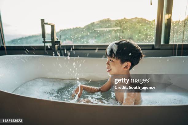 少年は風呂に座りながらシャワーから洗い流す」の動画素材 ロイヤリティフリー 1021318153Shutterstock