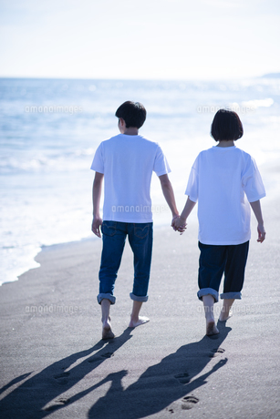 夕暮れに手を繋ぐカップルのシルエット 11031049026 の写真・イラスト素材アマナイメージズ