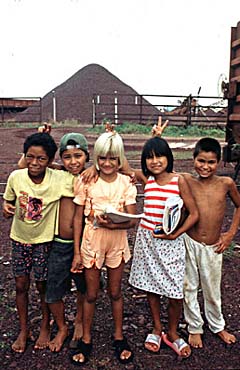 スタジオで人里離れた、アルビノの黒人の若者や陽気な白人女性など、カメラに向かって笑顔でポーズをとるさまざまな人種や民族の子供たち ジェネレーティブAIPremium AI生成画像