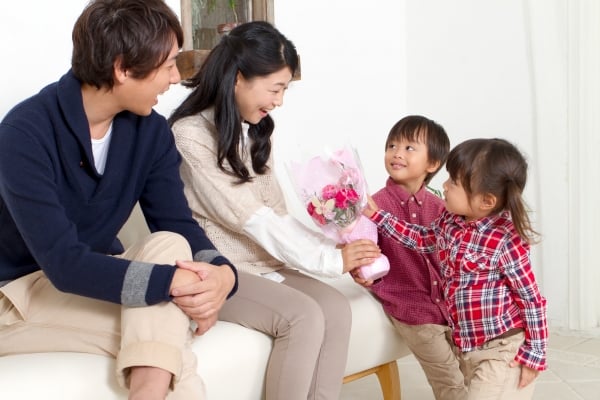 お母さんが赤ちゃんを抱きしめる母の日イラストと花のフレームPremiumベクトル素材