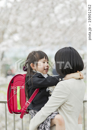 2人のボーイフレンドの小学生が学校に行く途中で路上でお互いをハグしています。Premium写真