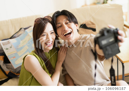 カメラの自撮りとカップルが笑顔でハグし、旅行新婚旅行や一緒に旅行するために港でポーズをとる愛の写真と旅行のインフルエンサーの人々がクルーズ船の休暇や休日の前に写真のために抱き合うPremium写真