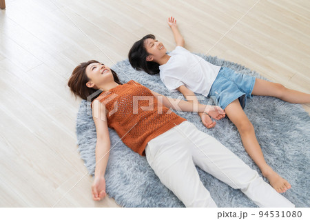 床に寝転ぶ女の子 11017020488 の写真・イラスト素材アマナイメージズ