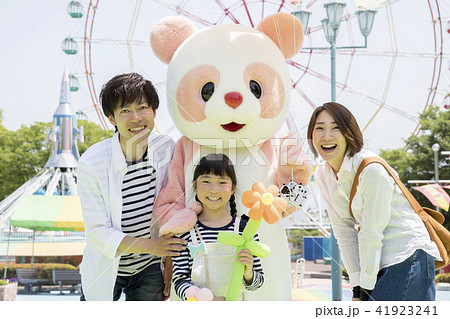 遊園地の美しいブロンドの女の子、彼女の手に風船の大きな束を持つ観覧車。ピンクとブルーの色。Premium写真