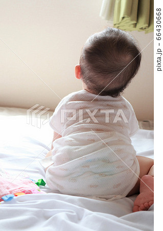 白いソファで掴まり立ちをする赤ちゃんの後ろ姿 10179015972 の写真・イラスト素材アマナイメージズ