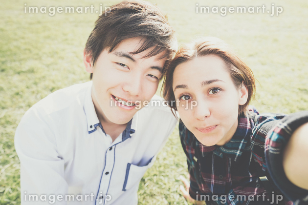 鏡の前に立ってカメラのポーズをとる男女の写真・画像素材-Snapmart スナップマート