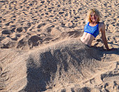 10代の女の子は砂浜で足を埋めます 夏休みのコンセプト ストック動画 © kravik93420247340