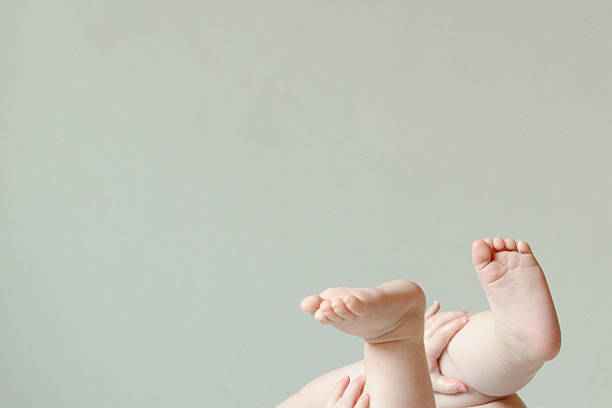 赤ちゃんの足を包むパパとママの手の写真・画像素材-Snapmart スナップマート