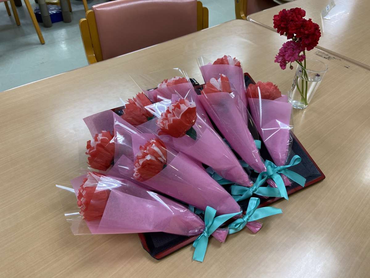 ５月１２日 日 は「母の日」 デイサービスの創作活動で 母の日の壁面飾りを利用者様と作りました。 折紙で一輪の花を作り、それを沢山集めて１つのブーケが完成。 母の日に贈る「ありがとう」の花束です。 お母ちゃんたちは、みんな元気に頑張っています！ ・女は