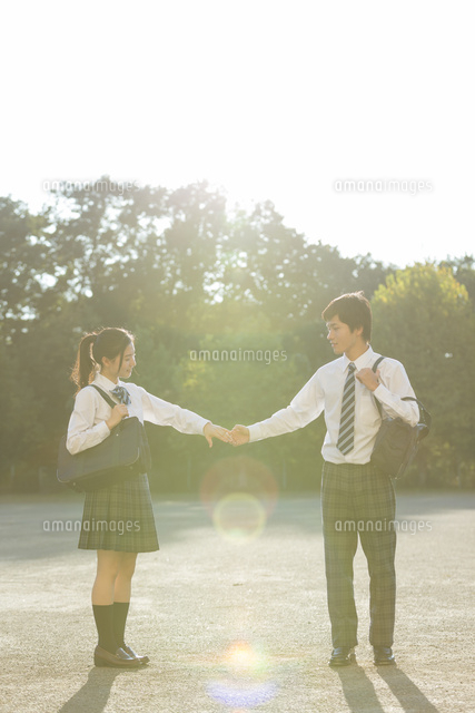 手をつなぐ高校生カップルの後姿 10904001686 の写真・イラスト素材アマナイメージズ
